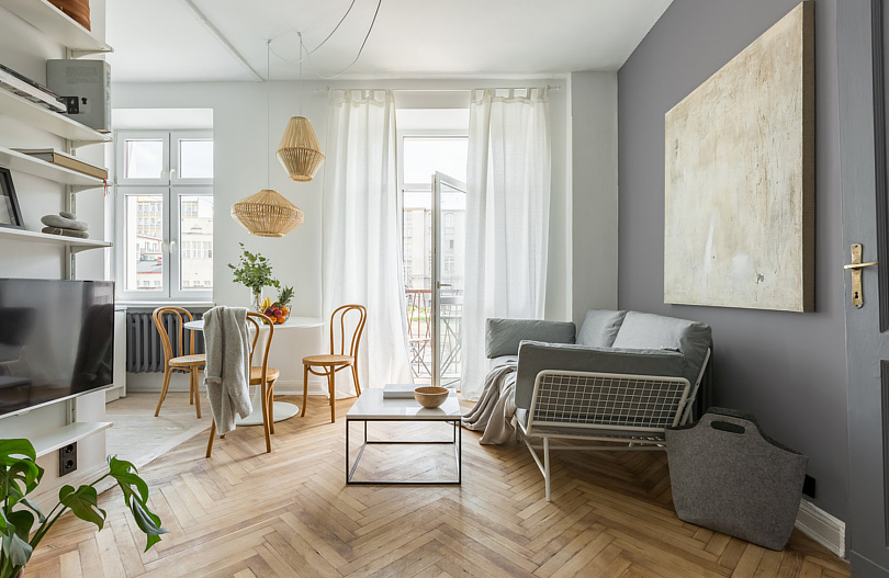 Salon z ciemną ścianą i parkietem w jodełkę